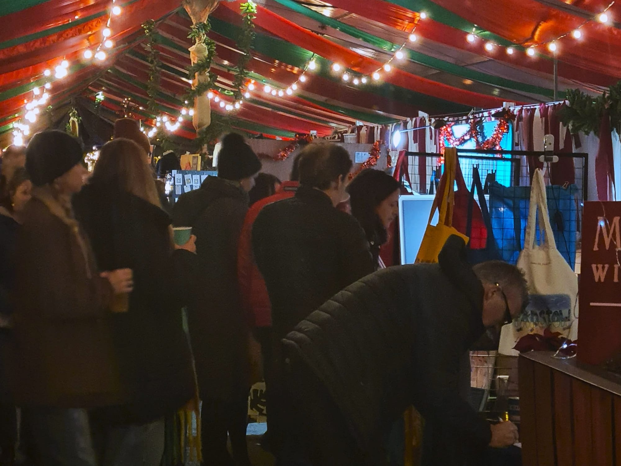 Shoppers browsing artisan stalls inside the Christmas Market tent